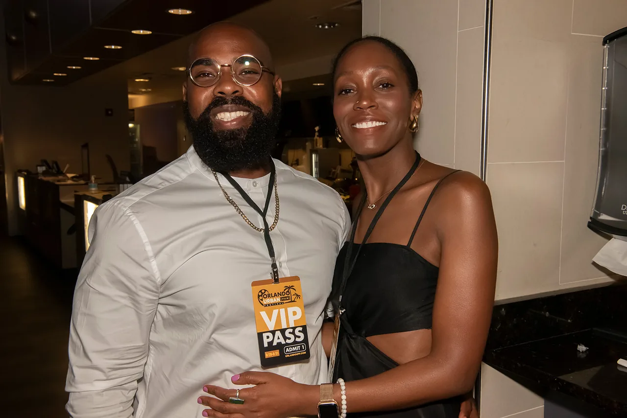 Two guests wearing VIP passes posing together at the festival