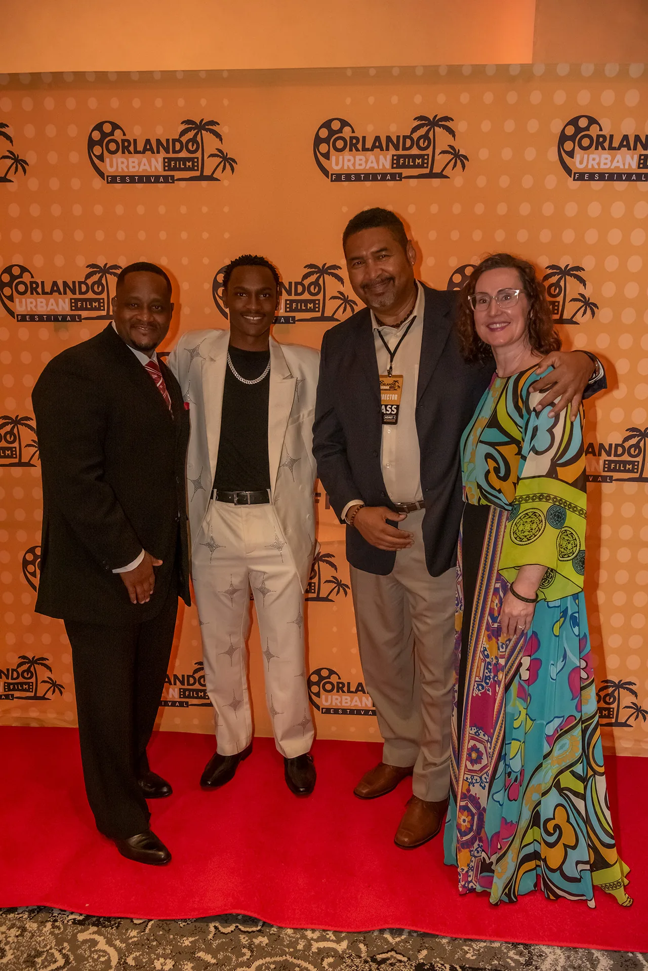 Four members of a film team posing together on the red carpet