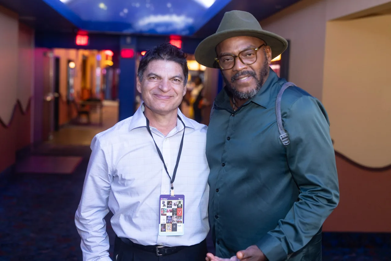 Two filmmakers greeting each other in the cinema corridor