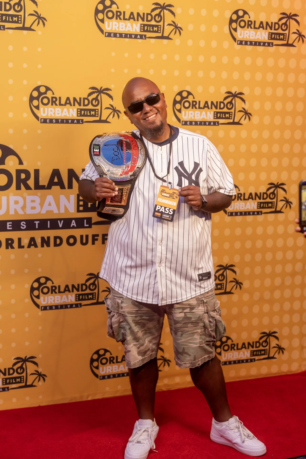 A guest on the red carpet holding up his award