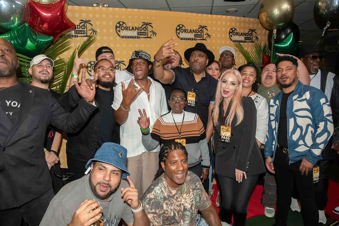 A large group of filmmakers crowded together for a group photo with balloons